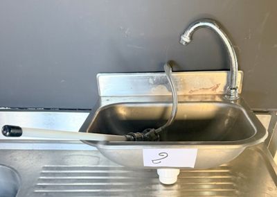 a metal sink with a metal faucet and a faucet attached to it