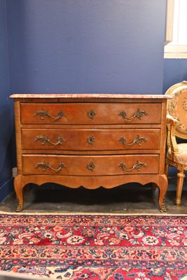 une commode et une chaise dans une pièce aux murs bleus
