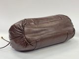an image of a brown leather bag sitting on top of a white surface