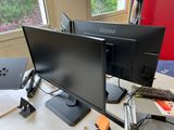 two monitors sitting on a desk next to each other