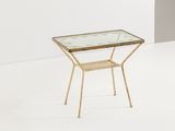 une table en verre avec des pieds dorés et un plateau en verre