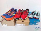 several pairs of running shoes sitting on top of a cardboard box
