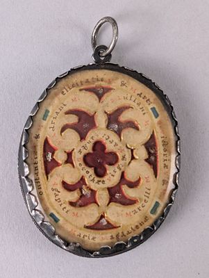 une photo d'un pendentif sur lequel figure l'image d'une fleur