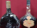three bottles of liquor are lined up on a red surface