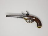 un vieux pistolet avec une poignée en bois sur une surface blanche