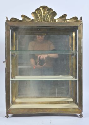 une vitrine en verre dans laquelle se trouve un homme tenant un appareil photo