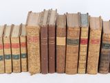 several old books stacked on top of each other on a white surface