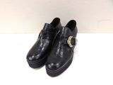 black leather shoes with buckles and a gold buckle on the side