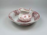 a red and white bowl with a creamer on it