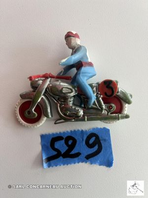une figurine représentant un homme à moto, sur laquelle figure un numéro