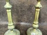 une paire de bougeoirs anciens en laiton sur fond marron