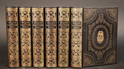 six livres aux couvertures noires et dorées empilés les uns sur les autres
