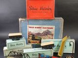 une pile de rails de train miniature et une boîte sur laquelle est accrochée une pancarte
