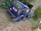 an old blue truck that is parked in front of a building