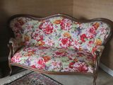 a floral couch in a room with a rug on the floor