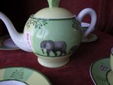 une théière ornée d'un motif d'éléphant, ainsi qu'une tasse et une soucoupe posées sur la table
