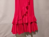 a pink skirt with ruffles hanging on a hanger