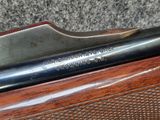 a close up of a gun with a wooden handle on a table