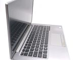 a silver laptop with a black keyboard on a white surface