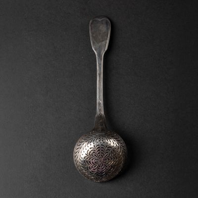 a spoon that is sitting on a black surface