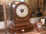 une horloge posée sur une étagère dans une vitrine