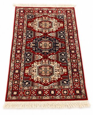 un tapis rouge et noir à franges sur fond blanc