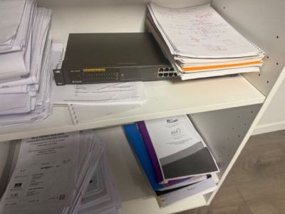 a shelf with a bunch of papers and a laptop on it