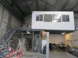 une photo d'un bâtiment avec un escalier et une mezzanine au-dessus