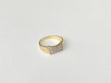 a close up of a gold and diamond ring on a white surface