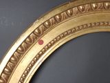 a gold frame with a red dot on it