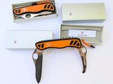 un couteau suisse orange et noir dans une boîte