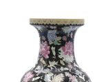 a black vase with pink and blue flowers on it