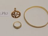 un gros plan sur une bague en or, une bague et une autre bague posées sur une surface blanche