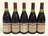 quatre bouteilles de vin sont alignées sur une surface blanche