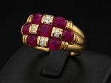 a close up of a gold ring with ruby and diamonds