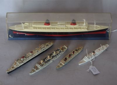 three model ships in a display case on a table