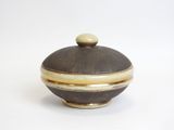 a brown and white bowl with a lid on a white surface
