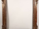a gold ornate frame with a white wall behind it