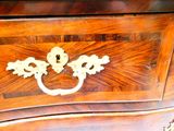 une commode en bois munie d'une poignée en laiton