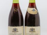 deux bouteilles de vin posées l'une à côté de l'autre sur une surface blanche