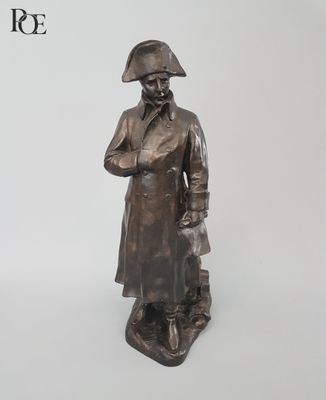 une vieille statue en bronze représentant un homme portant un chapeau et un manteau