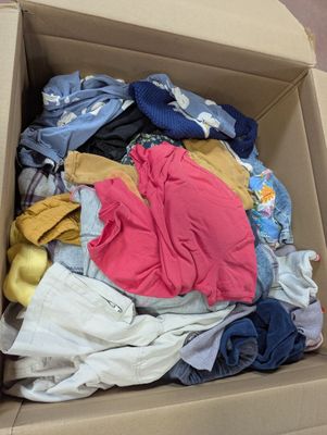 a cardboard box filled with clothes and other items