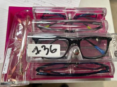 three pairs of glasses sitting in a box on a table