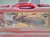 une boîte à outils rouge contenant tout un tas de tiges en bois
