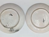 two white plates with black designs on them