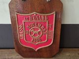 a wooden plaque with a red and gold emblem on it