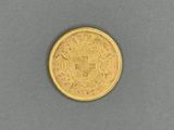 a close up of a gold coin on a gray surface