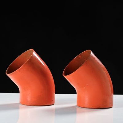 three orange pipes sitting on a white surface