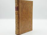 an old book sitting on top of a white surface
