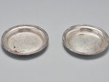 une paire d'assiettes argentées posées sur une table avec un fond blanc